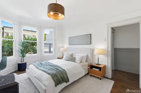 a bedroom with a bed and a potted plant
