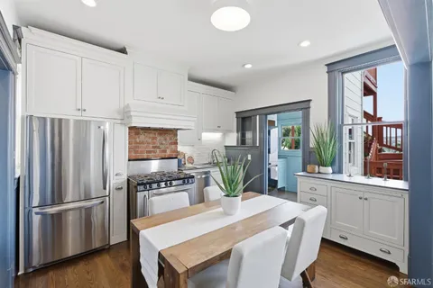 a kitchen with a refrigerator a stove and white cabinets