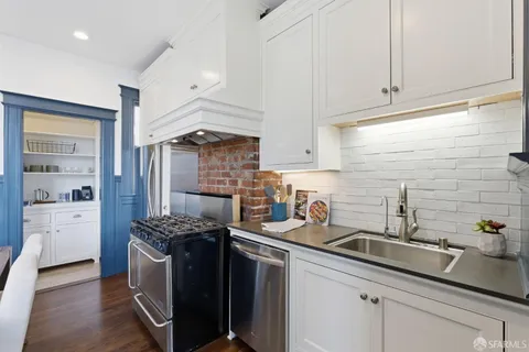 a kitchen with stainless steel appliances a sink stove and cabinets