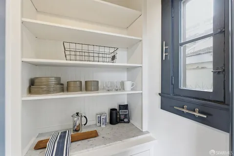 a kitchen with stainless steel appliances a dining table chairs refrigerator and sink