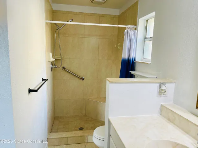 a bathroom with a shower and a sink