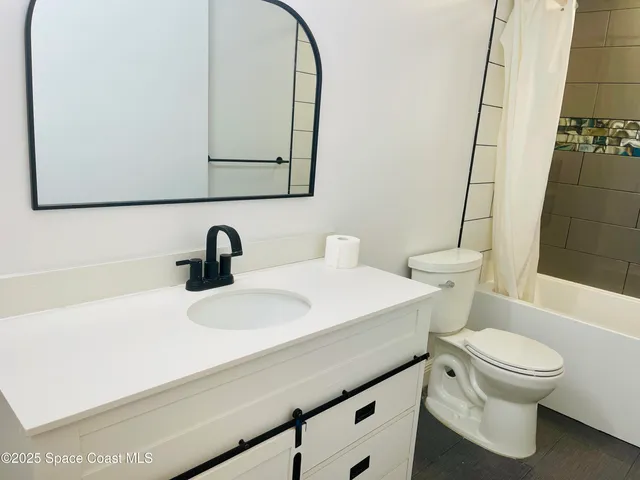 a bathroom with a sink a toilet and mirror