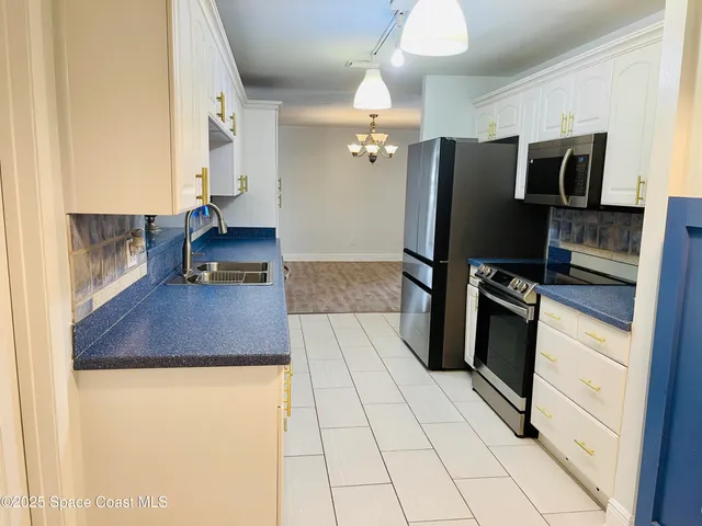 a kitchen with stainless steel appliances a refrigerator sink and microwave