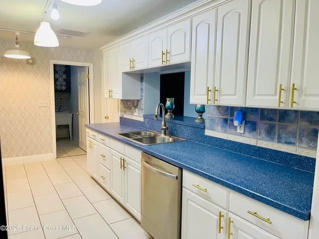 a kitchen with stainless steel appliances a sink dishwasher stove refrigerator and cabinets