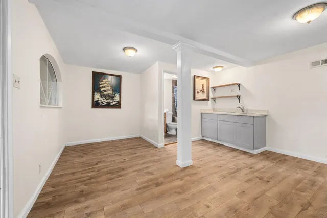 a room with a sink cabinets and wooden floor