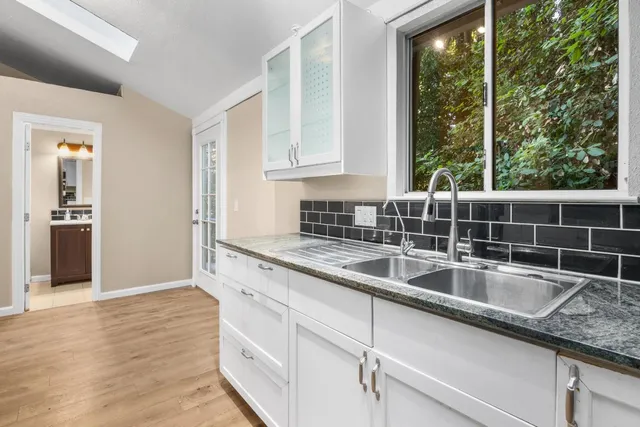 a kitchen with white cabinets and a stove top oven