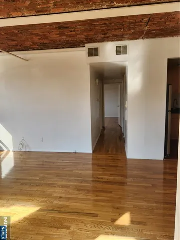 a view of kitchen and hallway with wooden floor