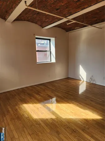 a view of a room with wooden floor and window