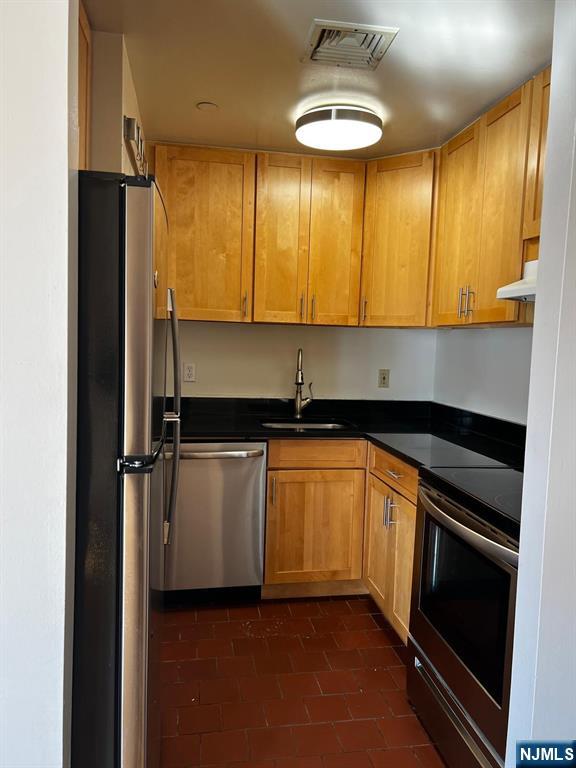 840 River Road, Unit 207 Edgewater, NJ 07020 - Photo 2 of 13 a kitchen with stainless steel appliances a refrigerator and sink