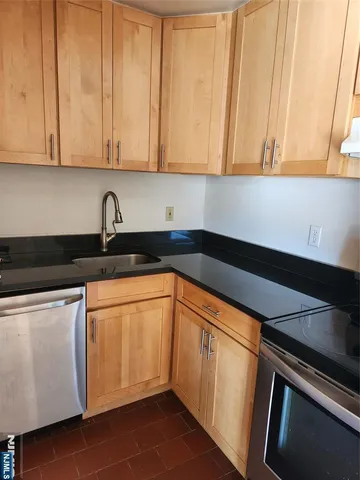 a kitchen with granite countertop white cabinets and sink
