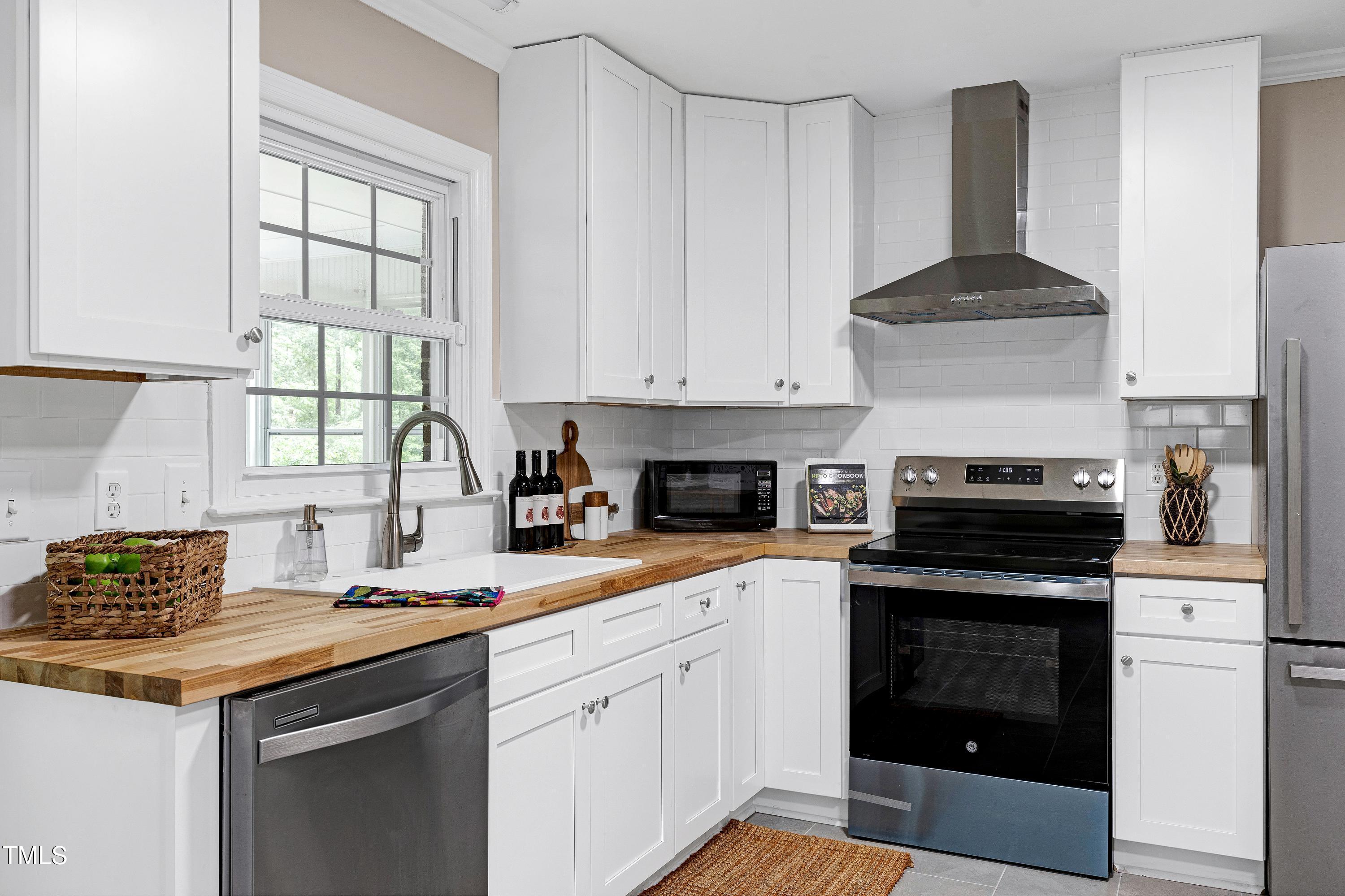 5121 Raintree Road Durham, NC 27712 - Photo 21 of 59 a kitchen with granite countertop a stove sink and cabinets