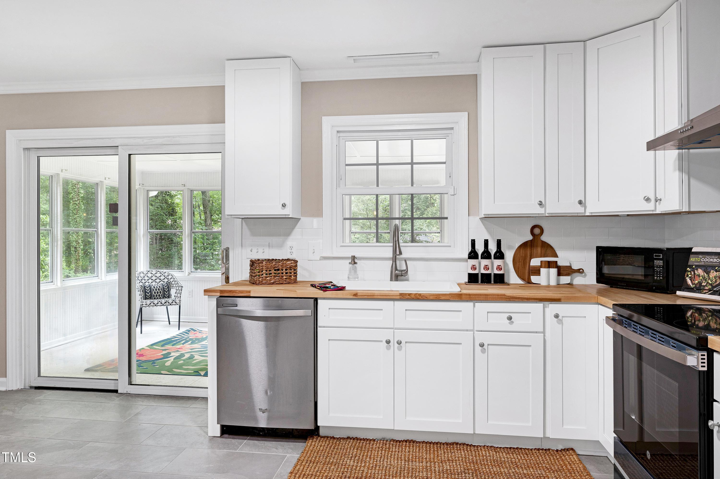 5121 Raintree Road Durham, NC 27712 - Photo 23 of 59 a kitchen with stainless steel appliances granite countertop a stove a sink and white cabinets