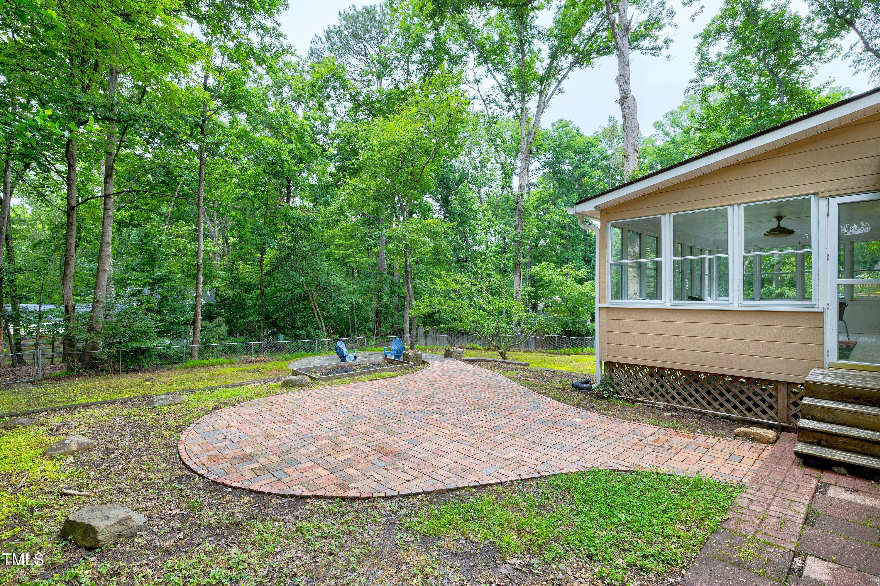 5121 Raintree Road Durham, NC 27712 - Photo 51 of 59 a small garden with trees in the background