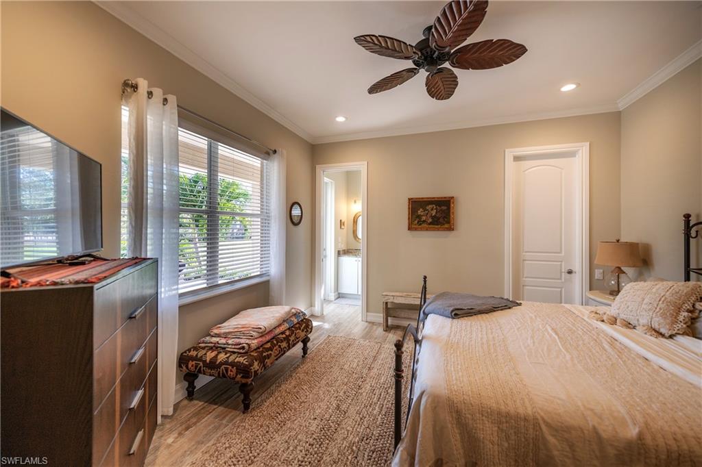 6610 Sable Ridge Lane Naples, FL 34109 - Photo 21 of 50 a bedroom with a bed and a chandelier