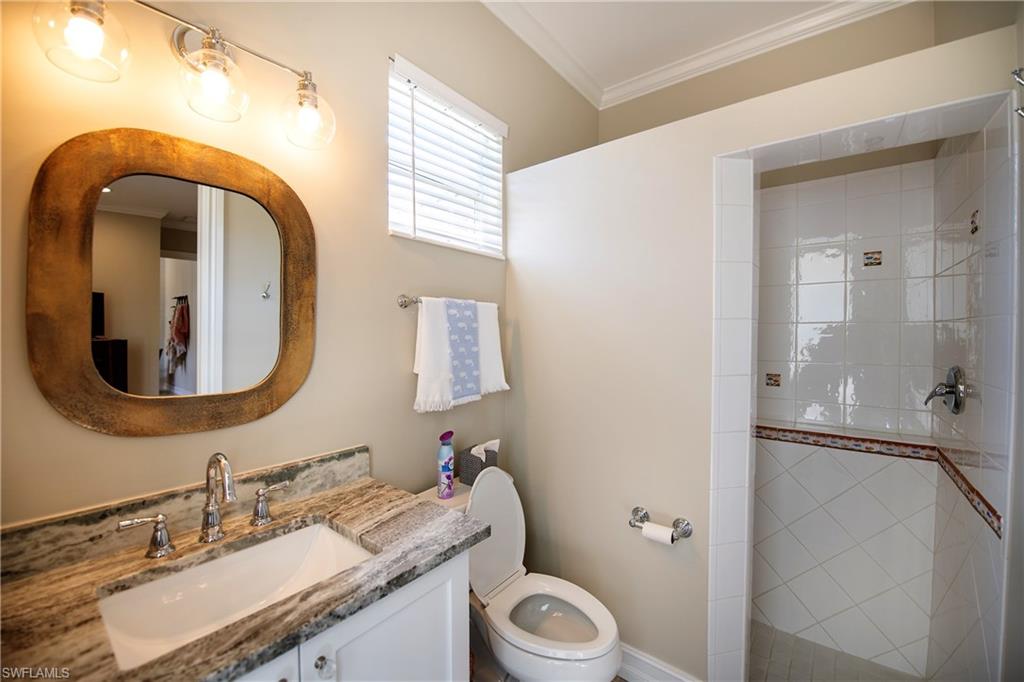 6610 Sable Ridge Lane Naples, FL 34109 - Photo 22 of 50 a bathroom with a granite countertop toilet sink and mirror
