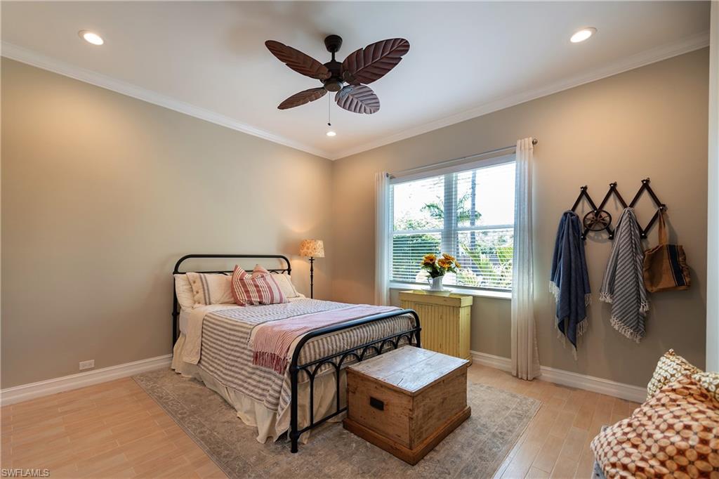 6610 Sable Ridge Lane Naples, FL 34109 - Photo 33 of 50 a bedroom with a bed and a chandelier