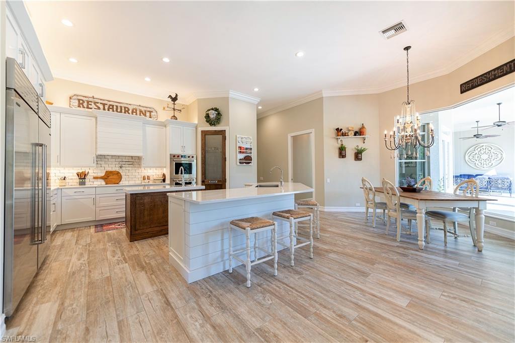 6610 Sable Ridge Lane Naples, FL 34109 - Photo 36 of 50 a large kitchen with cabinets table and chairs