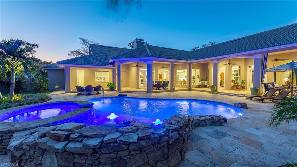 6610 Sable Ridge Lane Naples, FL 34109 - Photo 4 of 50 a view of swimming pool with red chairs in front of house
