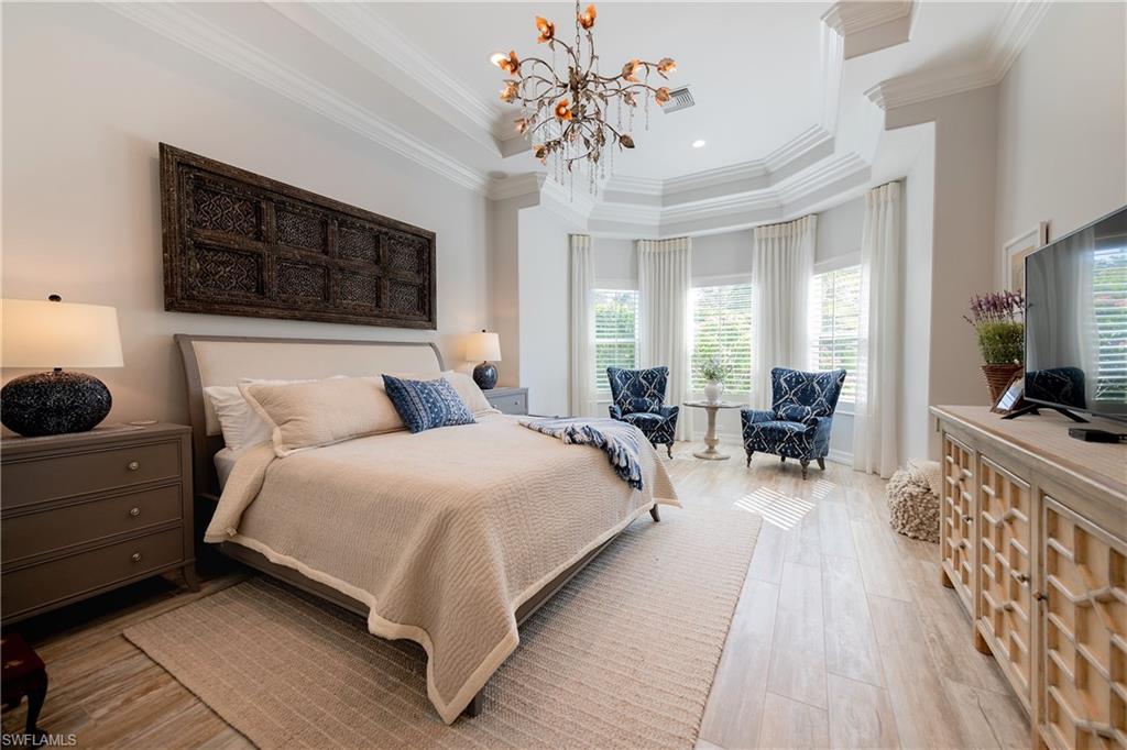 6610 Sable Ridge Lane Naples, FL 34109 - Photo 43 of 50 a spacious bedroom with a bed a couch and dresser