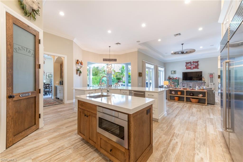 6610 Sable Ridge Lane Naples, FL 34109 - Photo 5 of 50 a kitchen with stainless steel appliances granite countertop a stove and a wooden floors