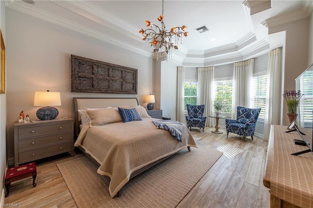 6610 Sable Ridge Lane Naples, FL 34109 - Photo 7 of 50 a spacious bedroom with a bed and wooden floor