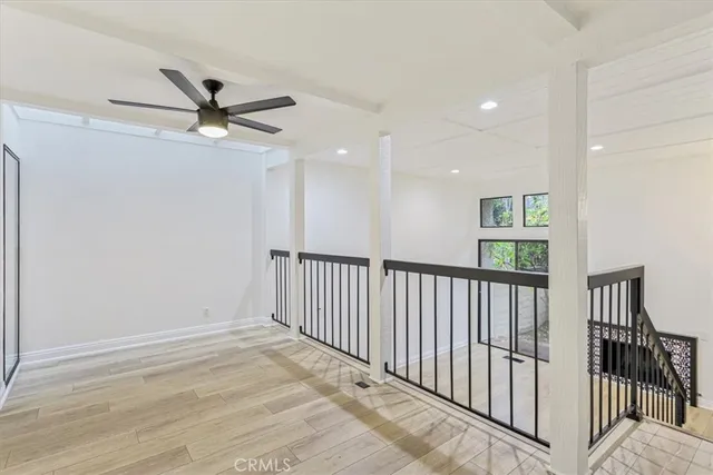 a view of a hallway with a ceiling fan