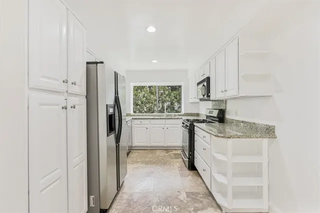 a kitchen with stainless steel appliances granite countertop a refrigerator and a stove