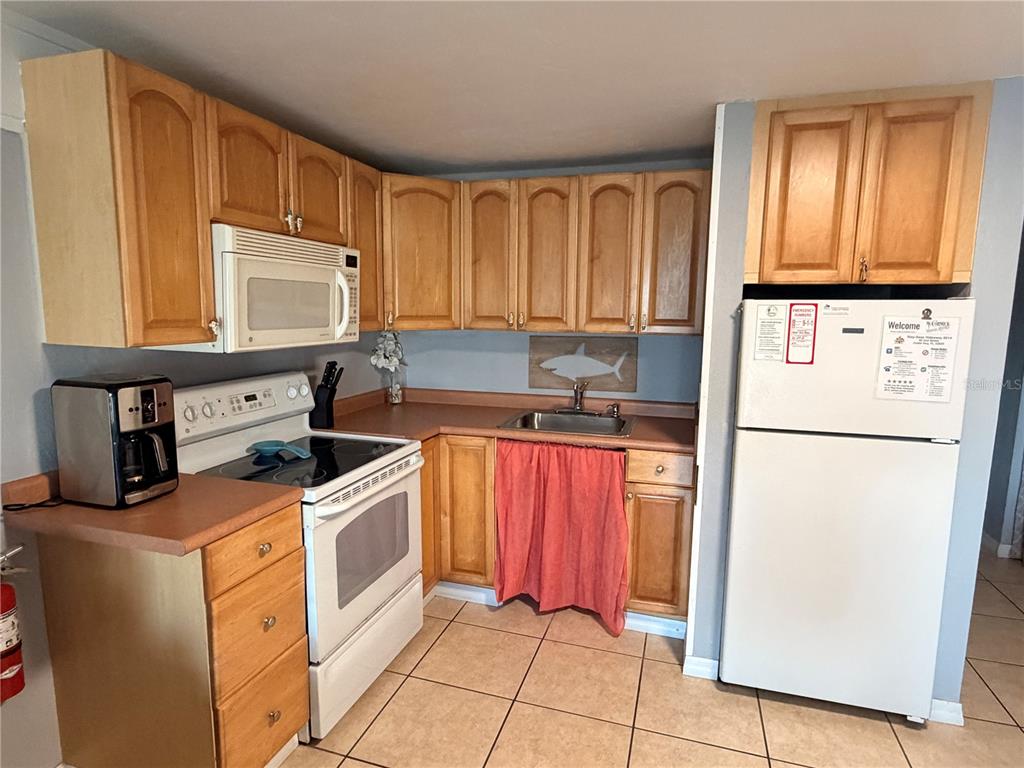 82 2nd Street, Unit D5 Cedar Key, FL 32625 - Photo 3 of 31 a kitchen with stainless steel appliances granite countertop a refrigerator sink and cabinets