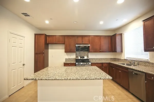 a kitchen with granite countertop sink cabinets and stainless steel appliances