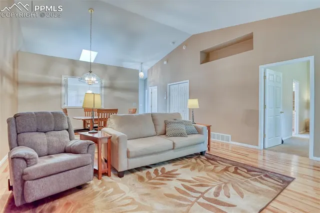 a bed sitting in a bedroom next to a window and a chandelier