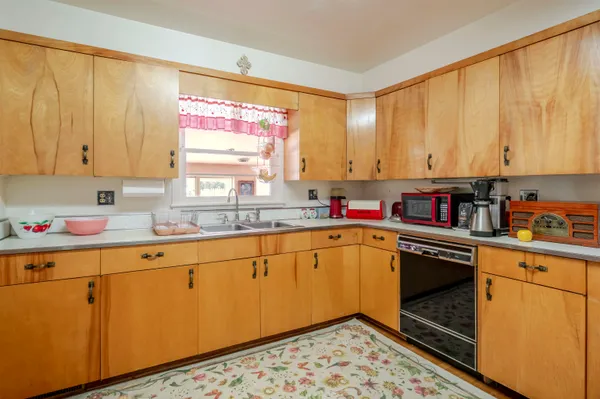 a bedroom with a bed a dresser and wooden floor
