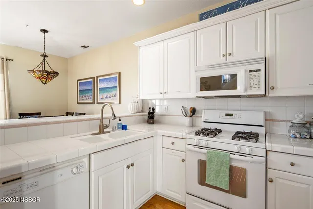 a kitchen with white cabinets and white appliances