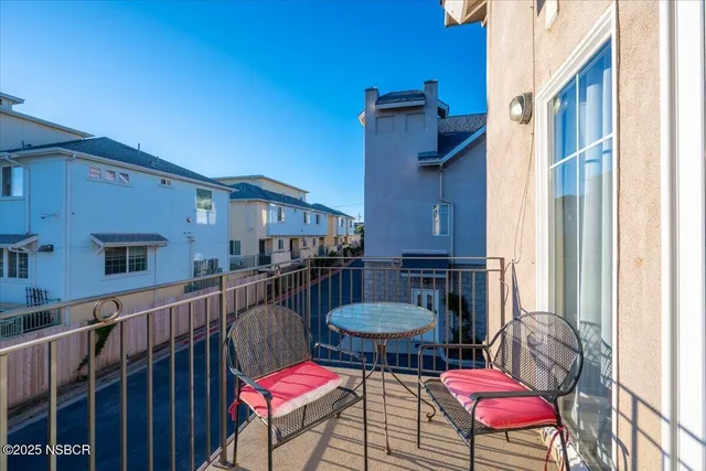 a view of a balcony with chairs and a potted plant