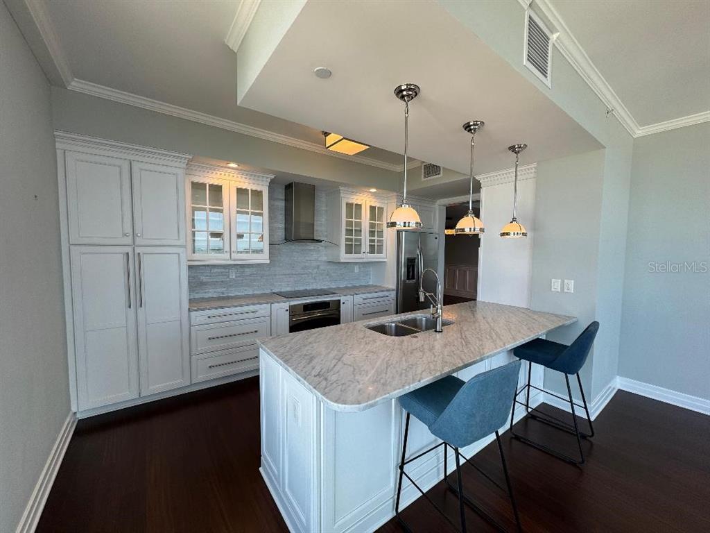 331 Cleveland Street, Unit 1504 Clearwater, FL 33755 - Photo 10 of 46 a kitchen with a table chairs refrigerator and microwave