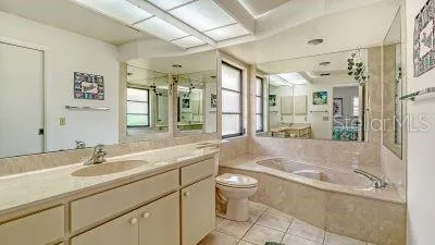 a bathroom with a granite countertop sink a toilet a mirror and shower