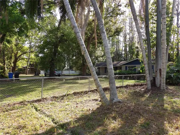 a view of a wooden house with large trees