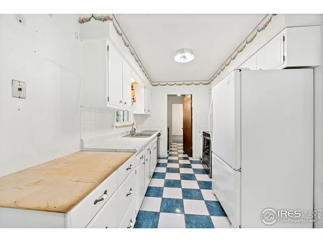 a kitchen with a checkered floor and white cabinets