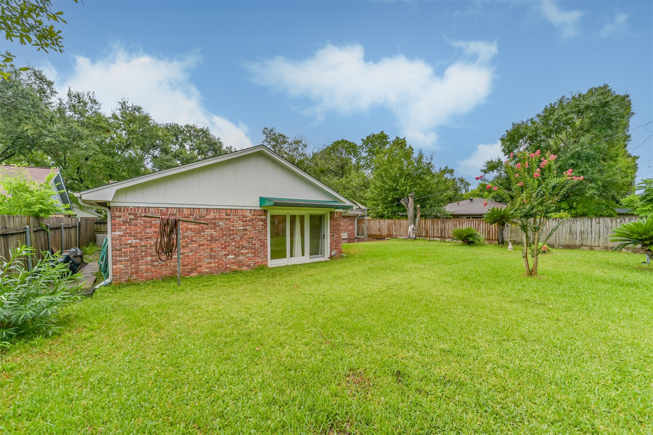 7510 Romney Road Houston, TX 77036 - Photo 29 of 32 Backyard with a view of the primary bedroom doors