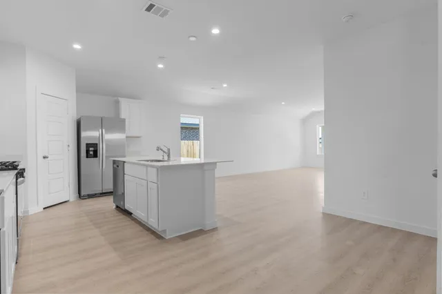 a view of a kitchen with refrigerator and white cabinets