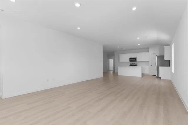 a view of a kitchen with a sink and dishwasher a refrigerator with wooden floor