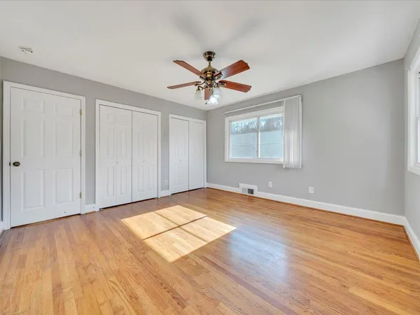a view of empty room with wooden floor