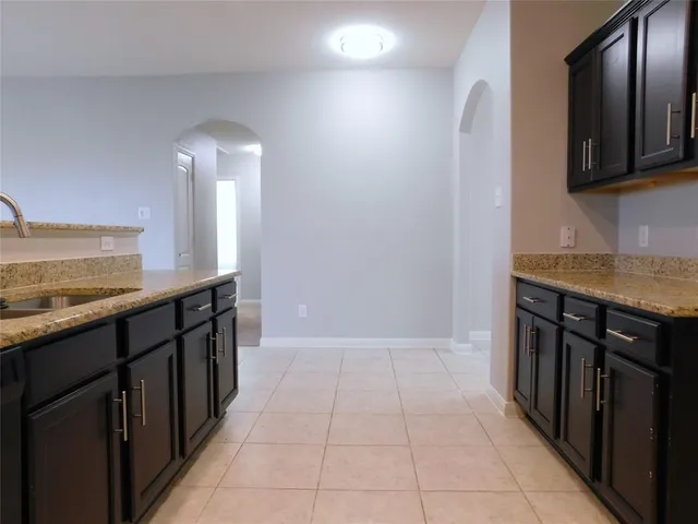 an empty room with a bathroom and a chandelier fan