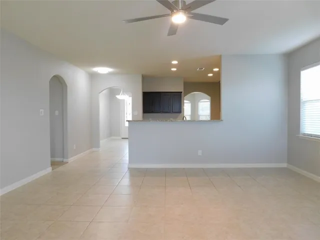 an empty room with windows and fireplace