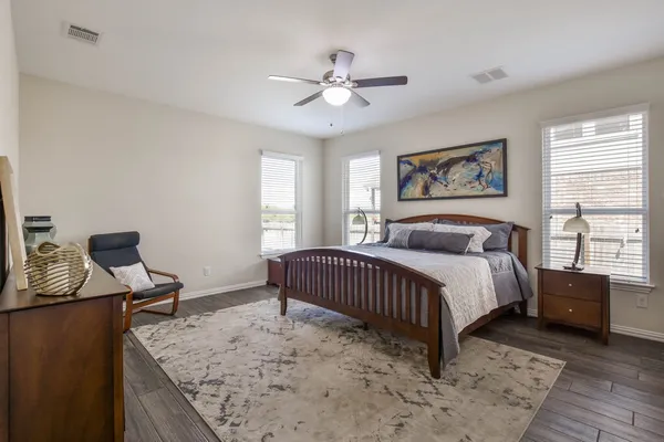 a spacious bedroom with a bed and a dresser