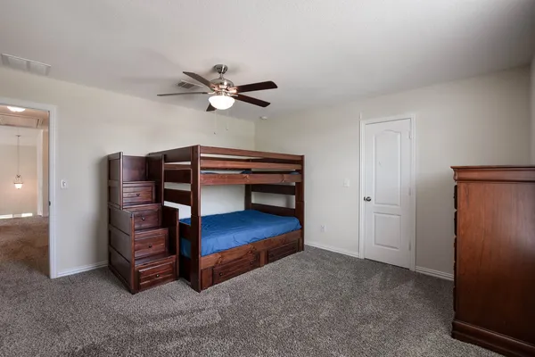a view of an empty room with a cabinet and a ceiling fan