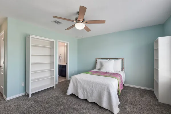 a bedroom with a bed and a ceiling fan