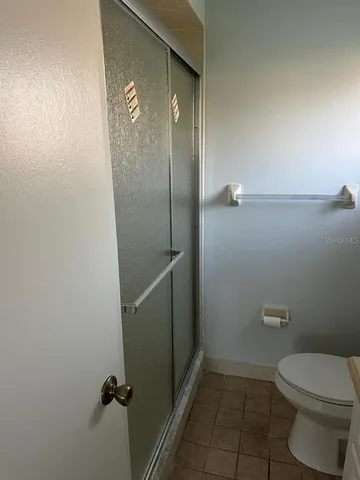a bathroom with a toilet and a shower