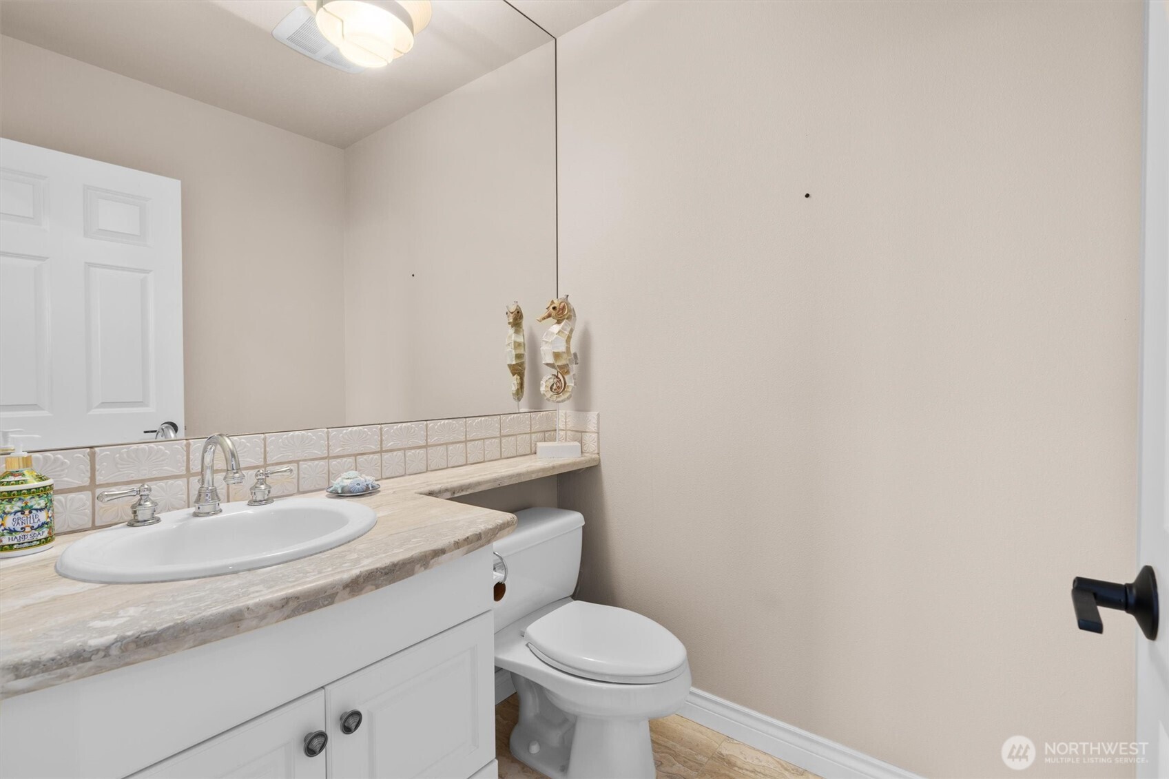 1005 Harbor Avenue Southwest, Unit 400 Seattle, WA 98116 - Photo 35 of 39 a bathroom with a granite countertop sink a toilet and a mirror