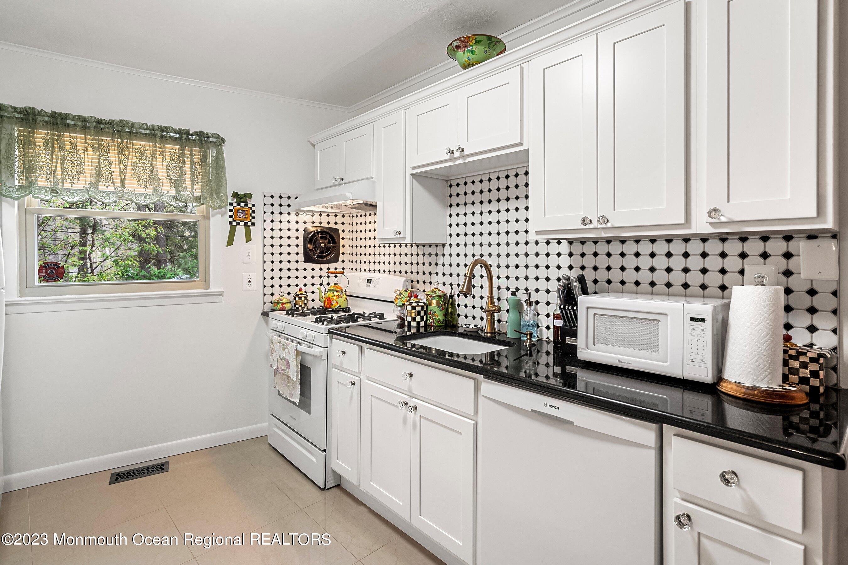 655 Burke Road Jackson, NJ 08527 - Photo 8 of 23 a kitchen with stainless steel appliances a sink a stove and white cabinets