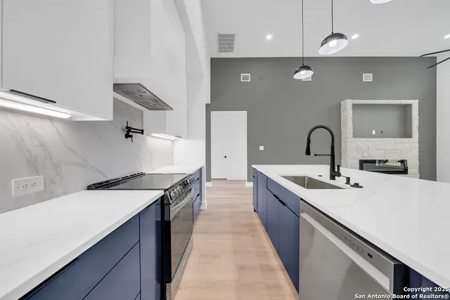a kitchen with a sink a stove and chairs